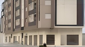 A multi-story building with a modern architectural design, featuring a combination of rectangular and square windows, and a flat roof. - Elegant Furnished S1 With Security in Ariana - Tunisia (La Soukra)