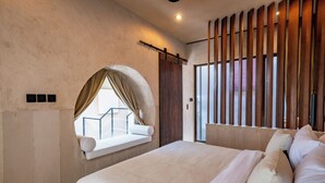 Une chambre moderne avec un grand lit, une fenêtre offrant une belle vue et une cloison en lattes de bois.