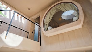 Un intérieur moderne avec une fenêtre circulaire, un balcon et un mur à texture.