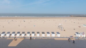 A beach with solar-powered charging stations, a sandy shore, and a clear sky. - Apartment With Marina View (Ostend)