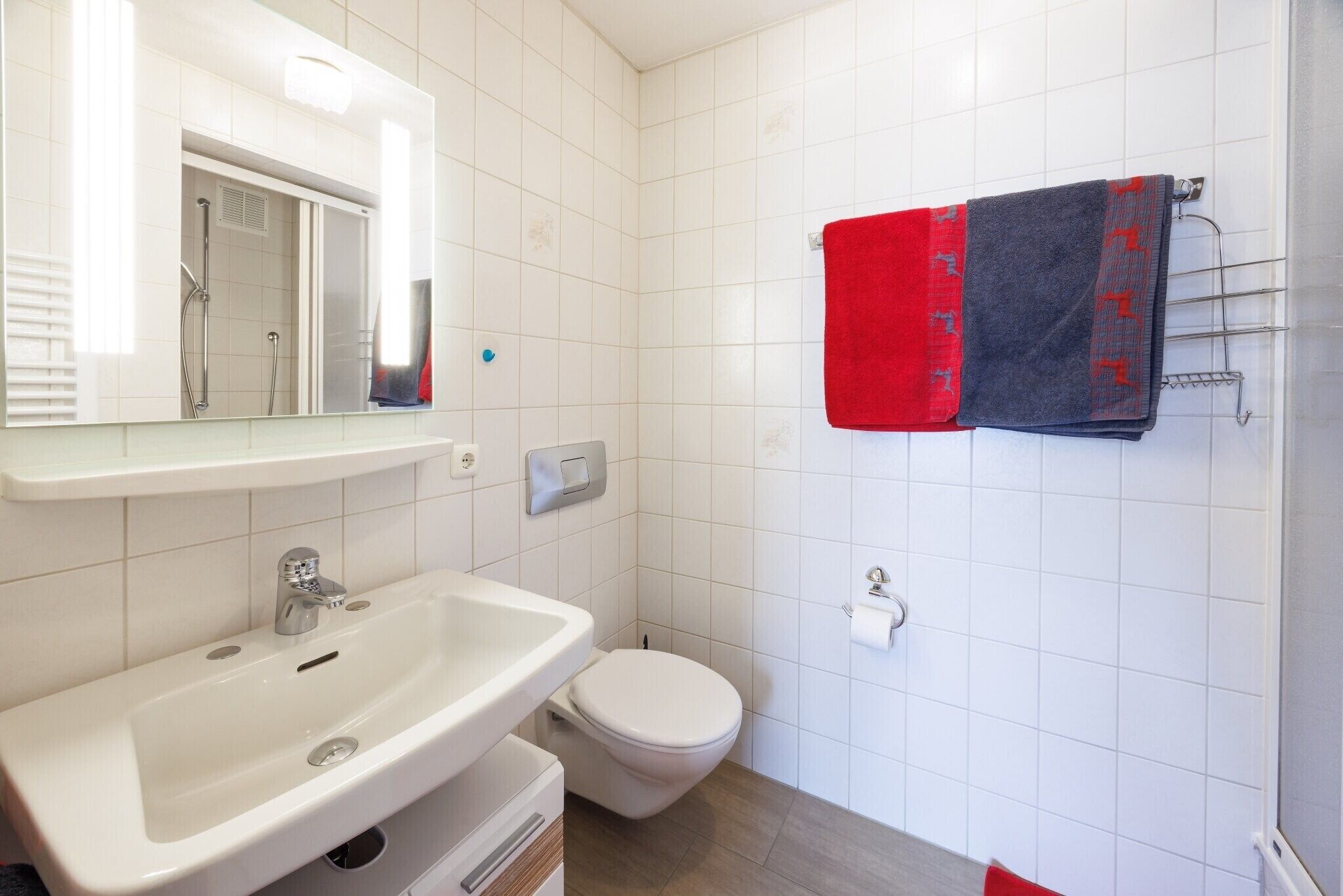 Ein Badezimmer mit Waschbecken, Toilette und Handtuchhalter.