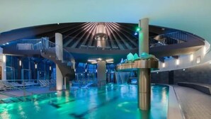 Una piscina interior con un elemento acuático central y una zona de visibilidad circular.
