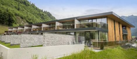 Un edificio moderno de dos pisos con techo plano, ventanas amplias y fachada de piedra.