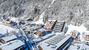 Un quartier résidentiel enneigé, avec des bâtiments modernes, notamment des immeubles à plusieurs étages et des maisons unifamiliales.