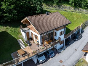 A two-story house with a balcony, a carport, and a driveway.
