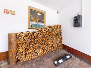 Ein Holzstoß an einer Wand mit einem Fenster und einem Rauchmelder.
