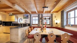 A wooden interior with a central island, seating, and a kitchen area.