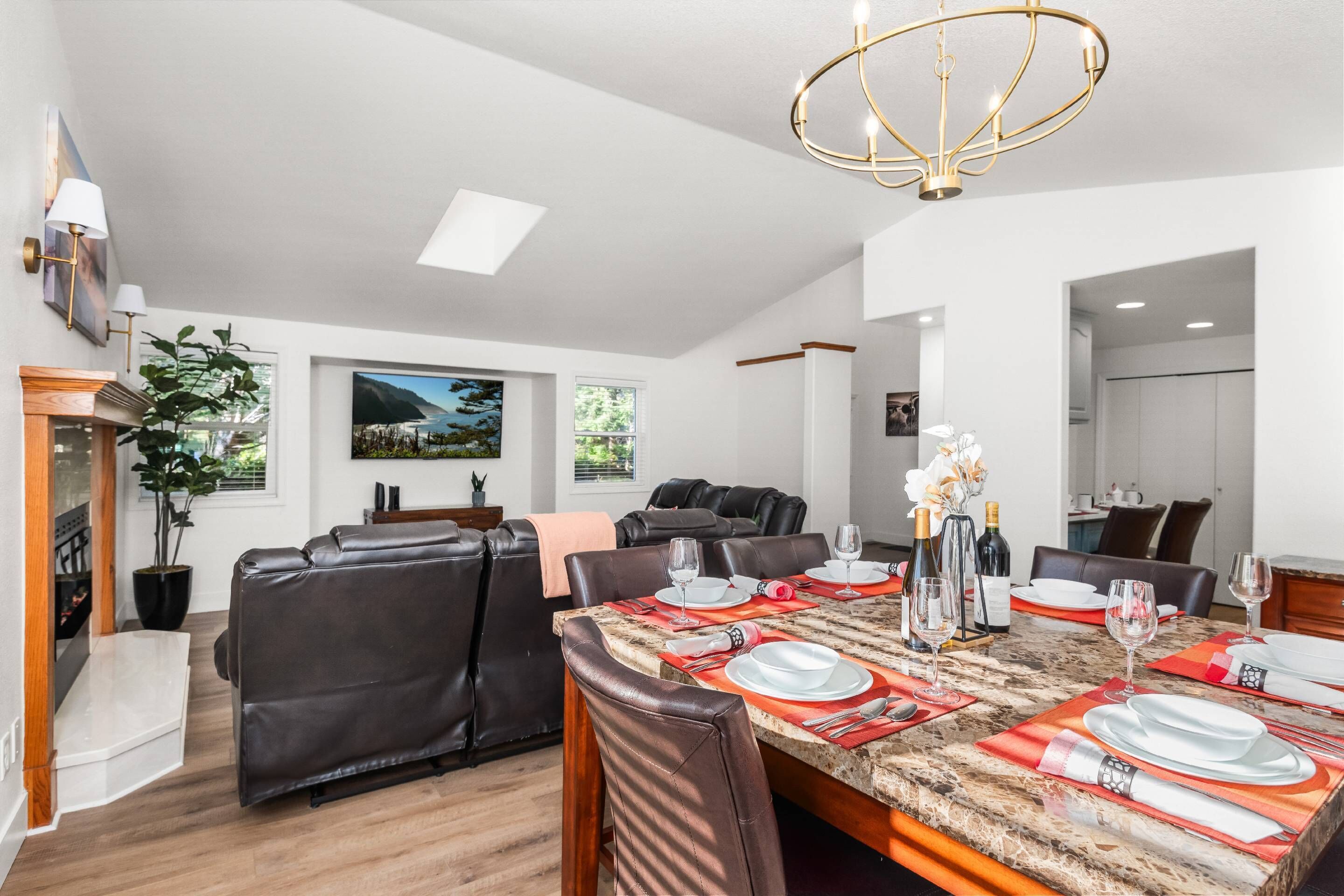 A dining area with a marble table set for four, surrounded by leather chairs.