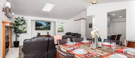 A dining area with a marble table set for four, surrounded by leather chairs.