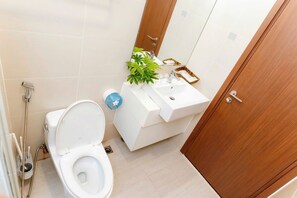A modern bathroom with a toilet, sink, and shower. - Cozy Apartment Ha Long Bay (Ha Long)