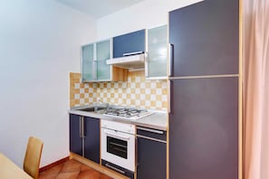 Une cuisine de taille réduite équipée d’une cuisinière à gaz, d’un four et d’un four à micro-ondes.