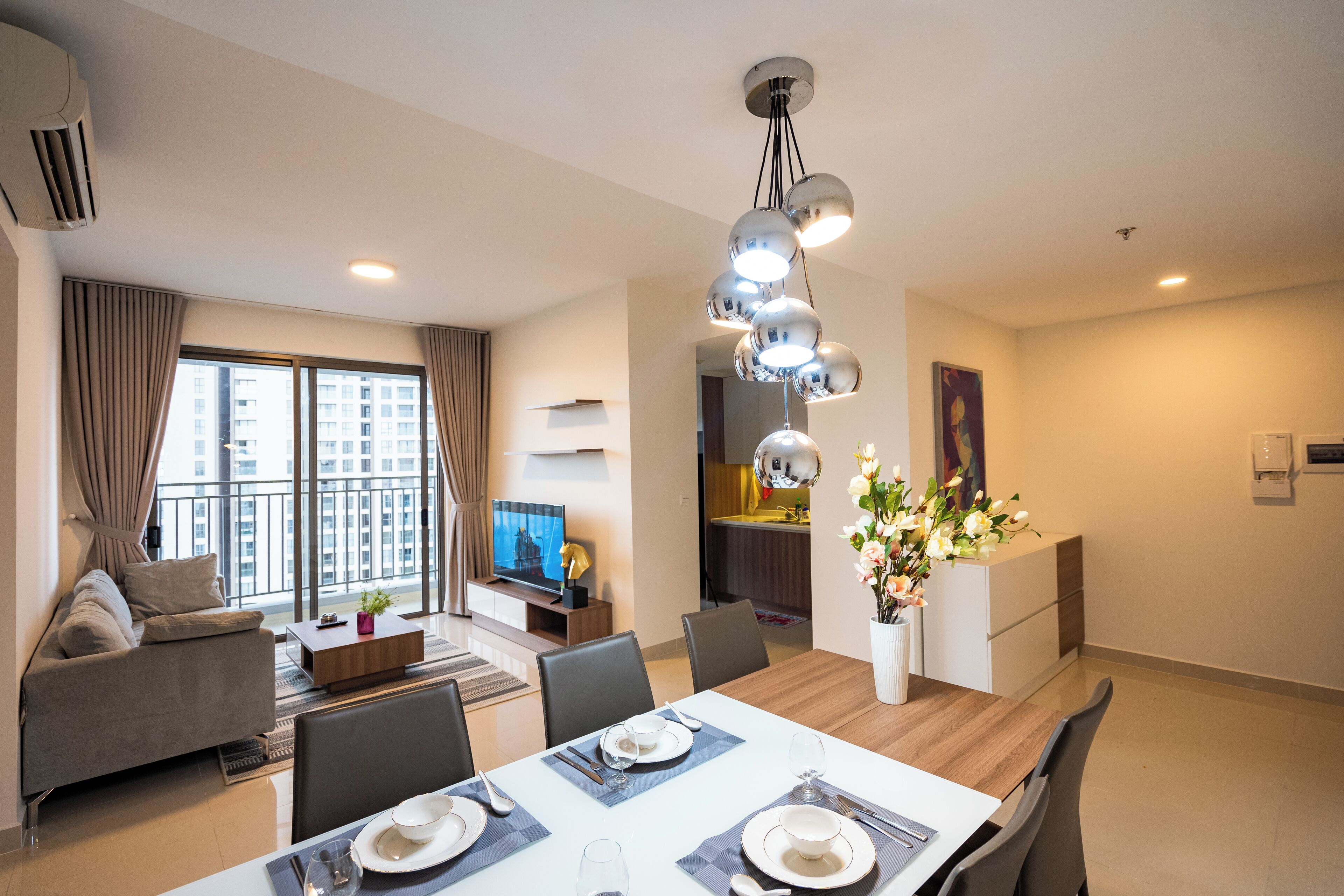 Ein modernes Wohnzimmer mit Essbereich, großen Fenstern und Blick auf die Stadt.