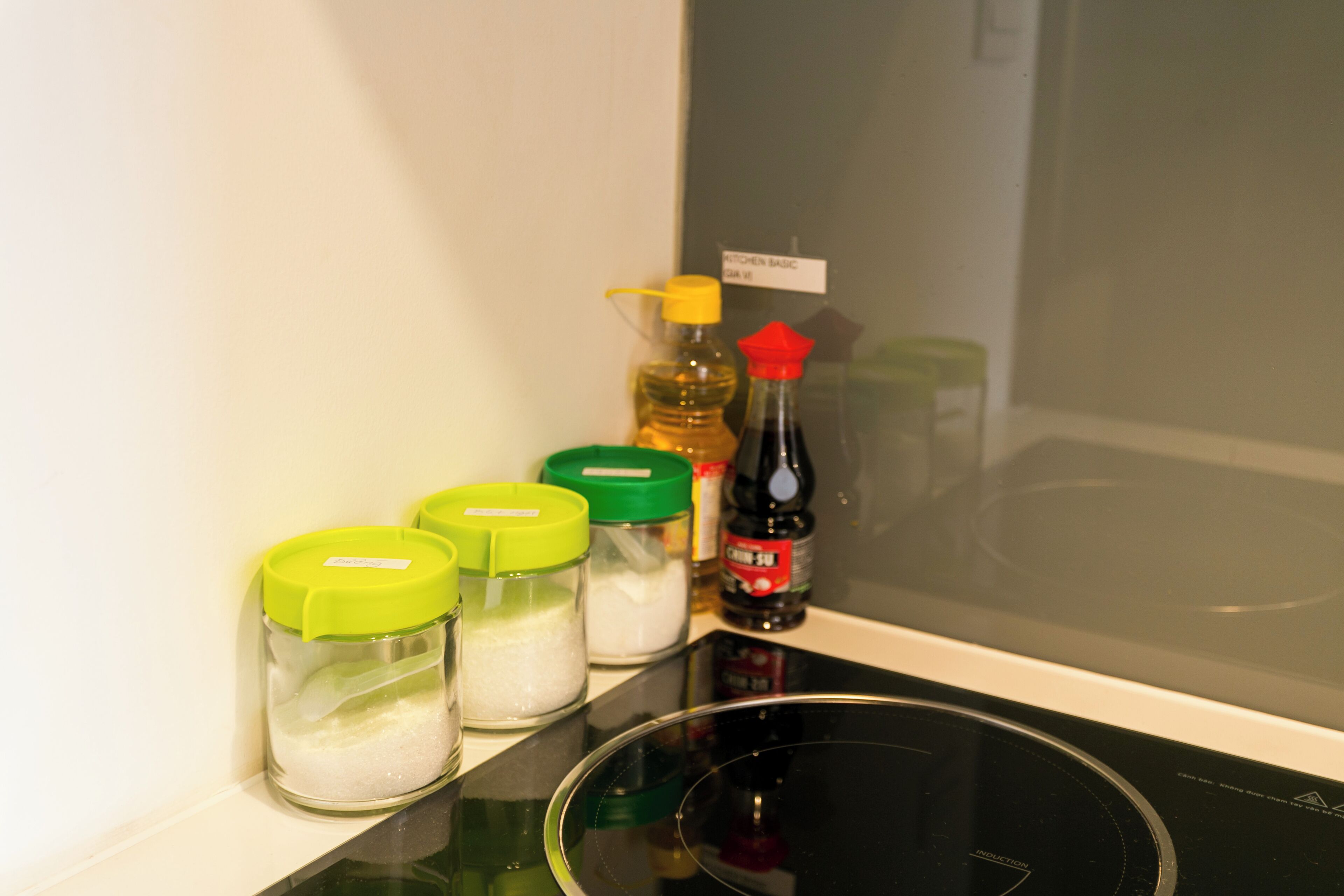 Un plan de travail de cuisine avec des récipients contenant du sel, du sucre et de l’huile de cuisson.
