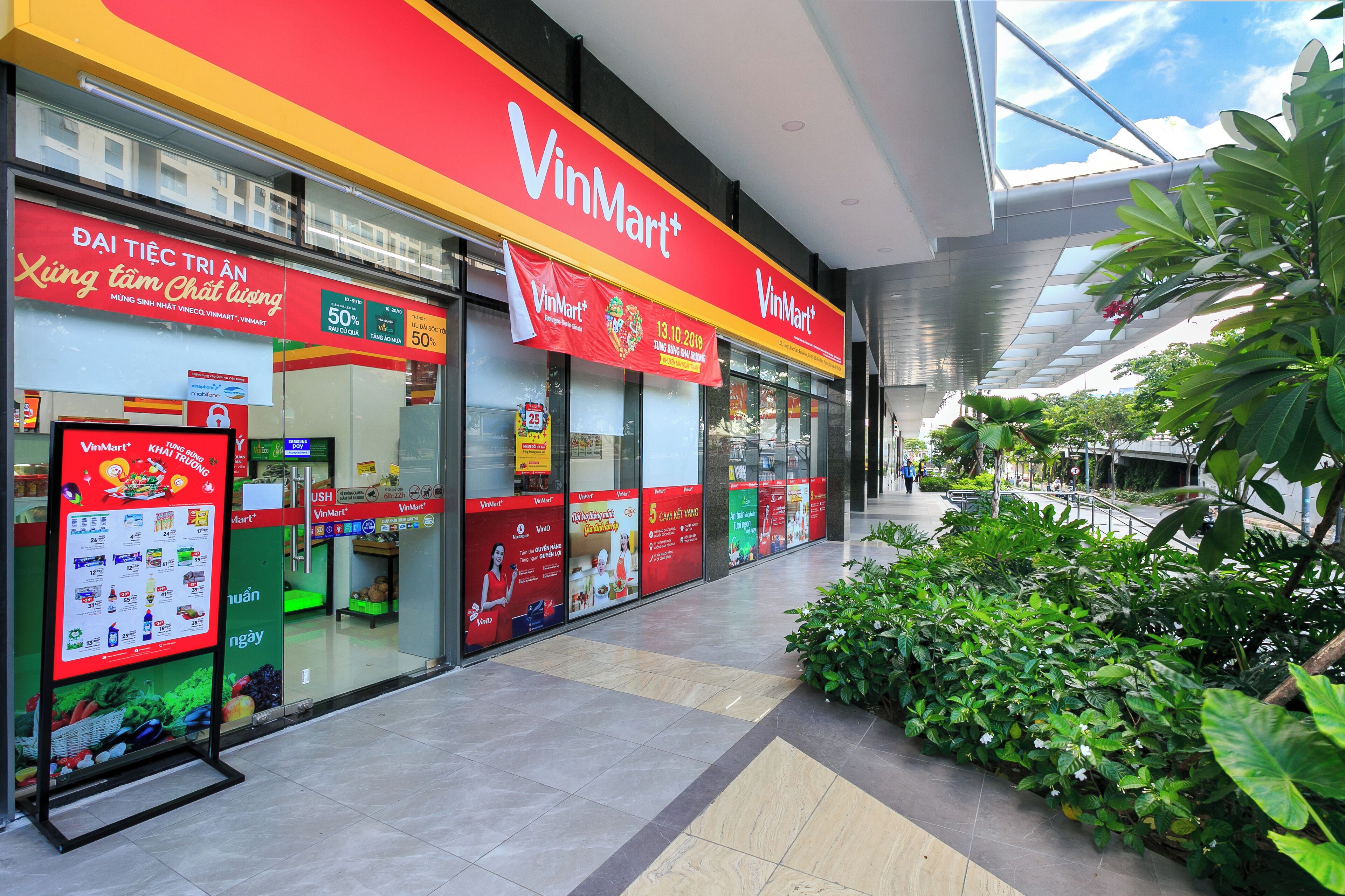 Een VinMart winkel met grote reclamebanners, een glazen gevel en een betegelde vloer.