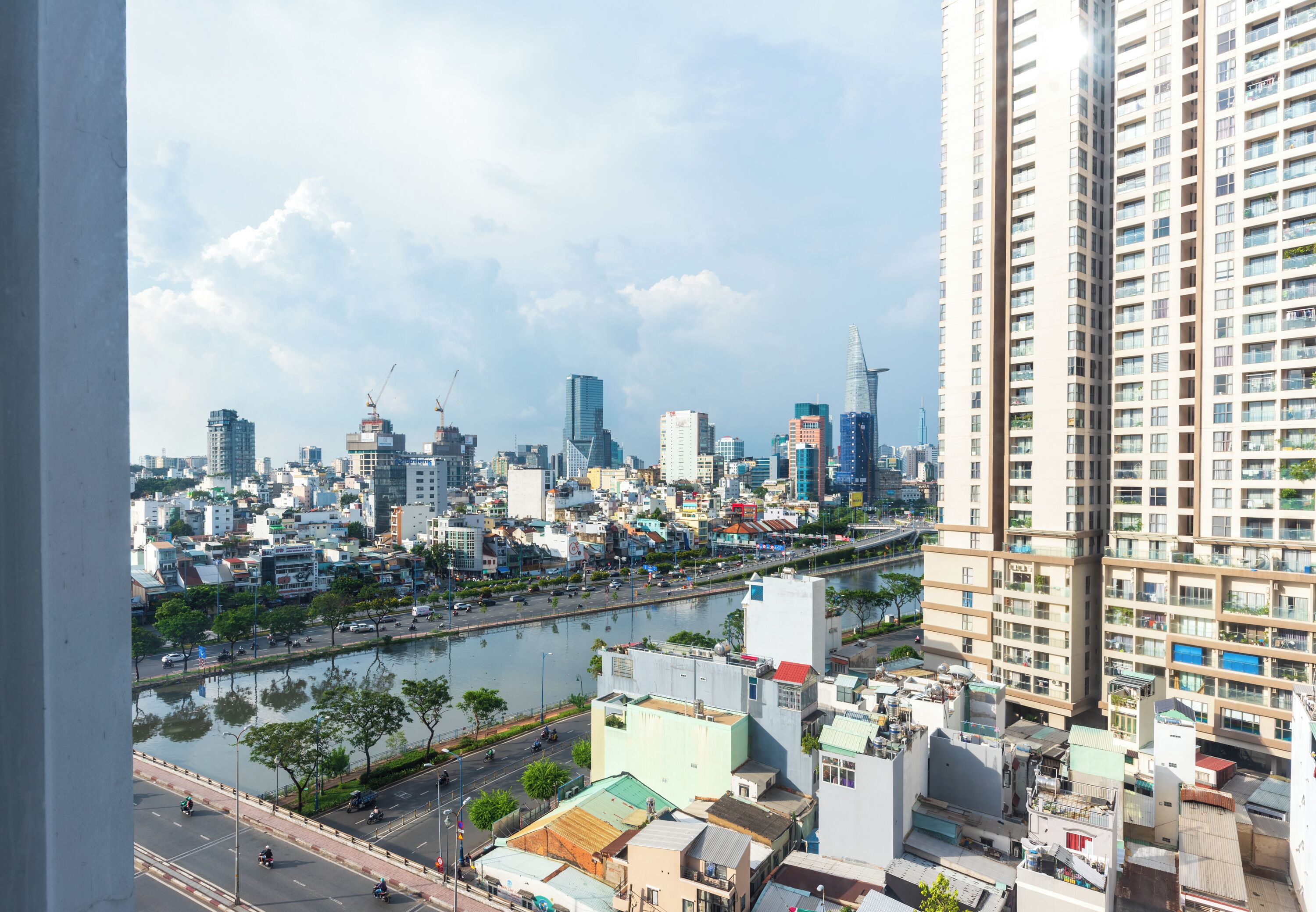 A cityscape with high-rise buildings, a river, and a bridge.