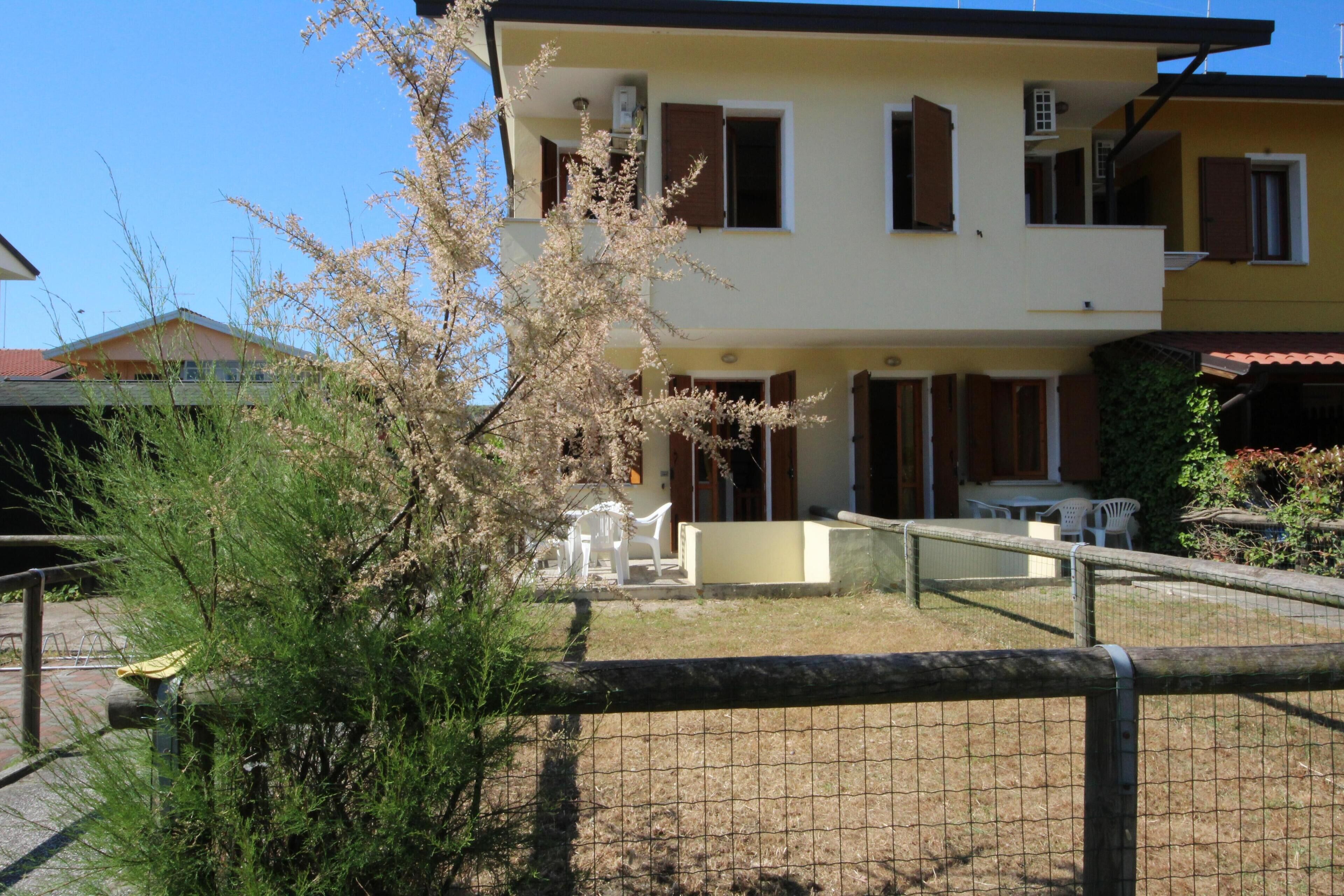 Un immeuble de deux étages doté d’un balcon, d’une cour clôturée et de mobilier d’extérieur.