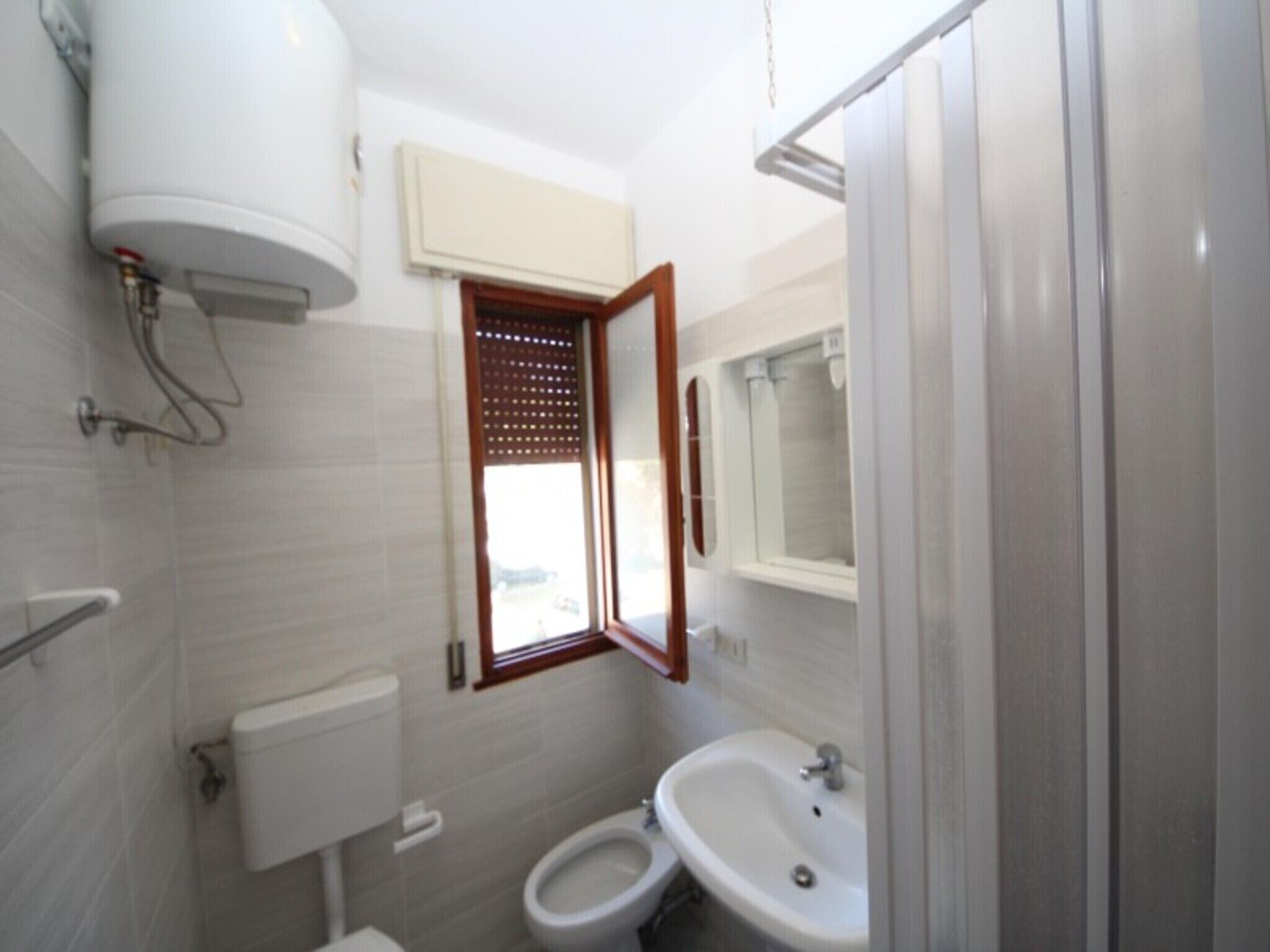 A compact bathroom with a toilet, sink, and shower.