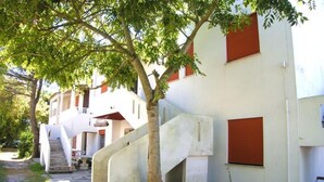 A building with a staircase leading to a landing, surrounded by trees. - Cozy apartment close to the beach (Rosolina Mare)