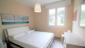 Une chambre à coucher avec un lit, une table de chevet et une fenêtre donnant sur l’extérieur.