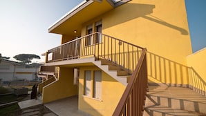 Un bâtiment jaune doté d’un balcon et d’un escalier menant à l’étage supérieur.