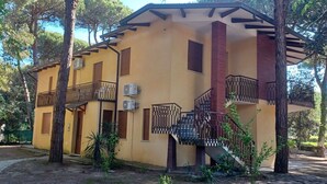 A yellow building with a balcony and a staircase. - Comfortable apartment in lovely Rosolina Mare (Rosolina Mare)