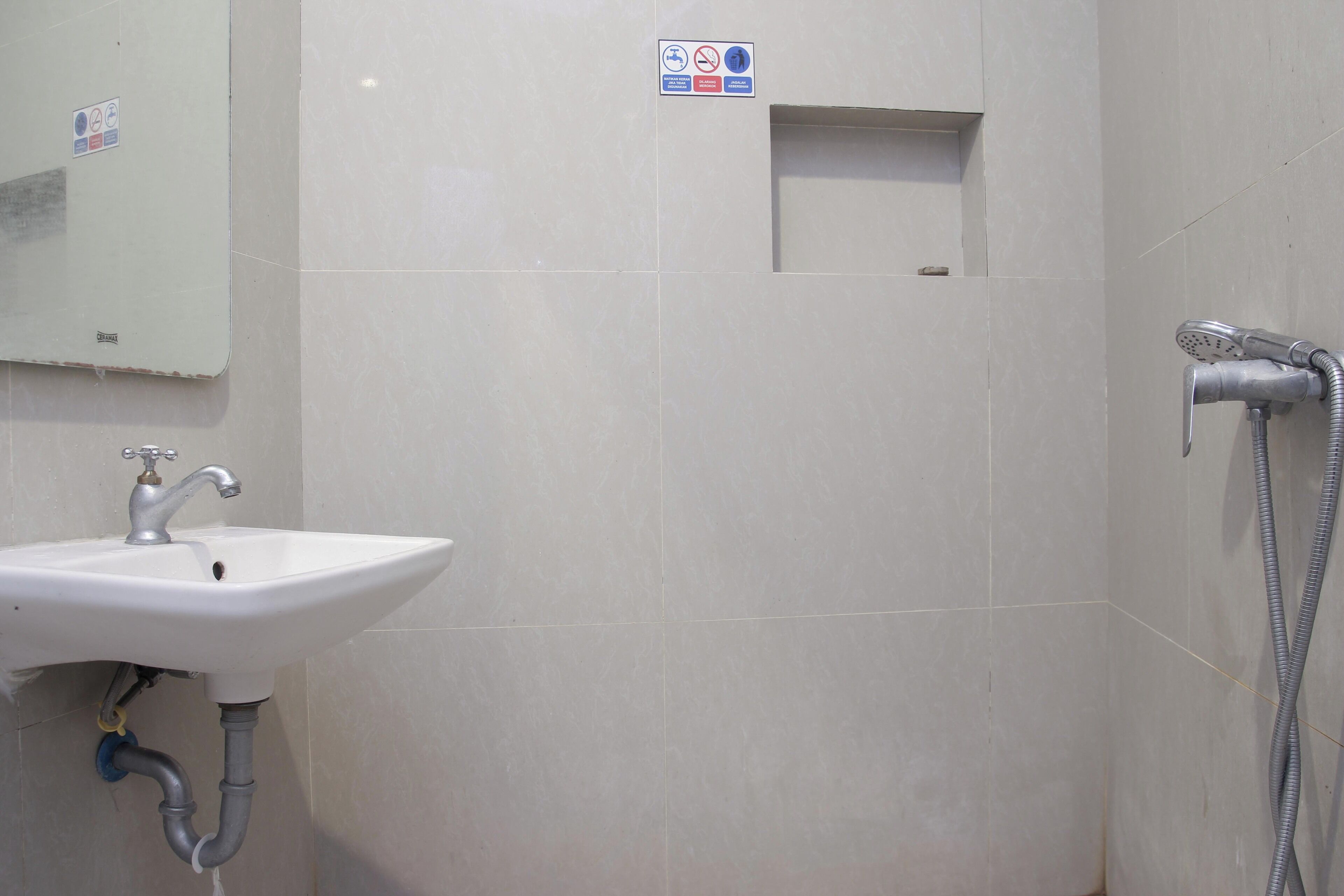 A bathroom with a sink, a mirror, and a shower.
