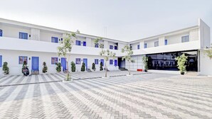 A courtyard with a paved floor, multiple doors, and a large glass entrance.