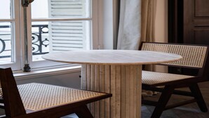 A round table with a wooden base and two wicker chairs. - Elegant apartment - 1BR/4P - Rue Saint-Honoré (Paris)