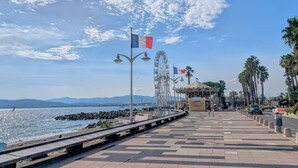A seaside promenade with a Ferris wheel, palm trees, and a clear sky. - Studio Azur, terrace, parking, 10min from sea (Fréjus)