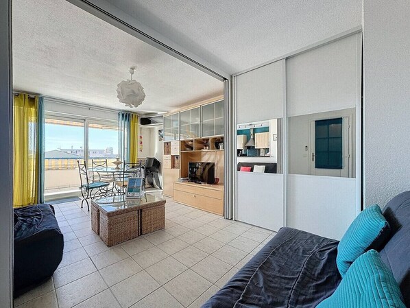 Un salon moderne comprenant un canapé, une table basse et un coin repas avec des chaises et une table.