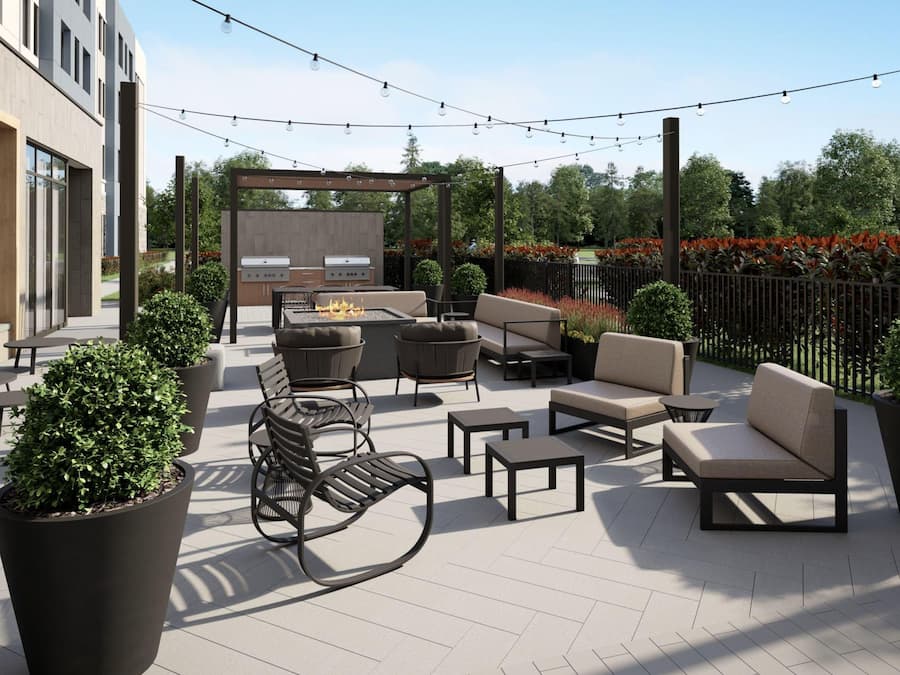 Un patio al aire libre con asientos, una parrilla y luces colgantes.
