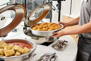 Montaje de bufé con diferentes opciones de comida, incluyendo un tazón de frituras y un tazón de salsa.