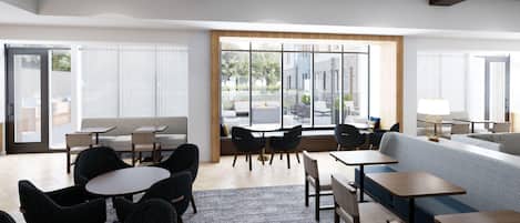 Eine moderne Hotellobby mit Sitzbereichen, Tischen und großen Fenstern mit Blick ins Freie.