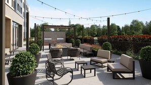 Une terrasse extérieure avec des sièges, un barbecue et des guirlandes lumineuses.