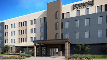 A modern hotel with a flat roof, large windows, and a covered entrance.