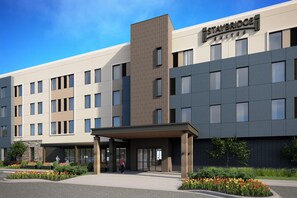A modern hotel with a flat roof, large windows, and a covered entrance. - Staybridge Suites Clermont Southeast (Clermont)