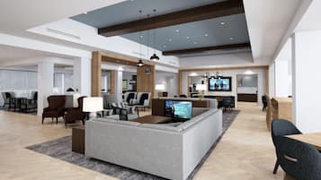 Un hall d’hôtel spacieux, doté d’un grand espace salon, d’un téléviseur et d’un comptoir d’accueil.