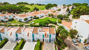 Un quartier résidentiel situé sur la côte, caractérisé par des bâtiments blancs, de vastes pelouses verdoyantes et une vue sur la mer.