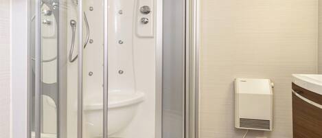 Une salle de bain moderne avec une douche à parois de verre, des toilettes et un meuble-lavabo avec un miroir.