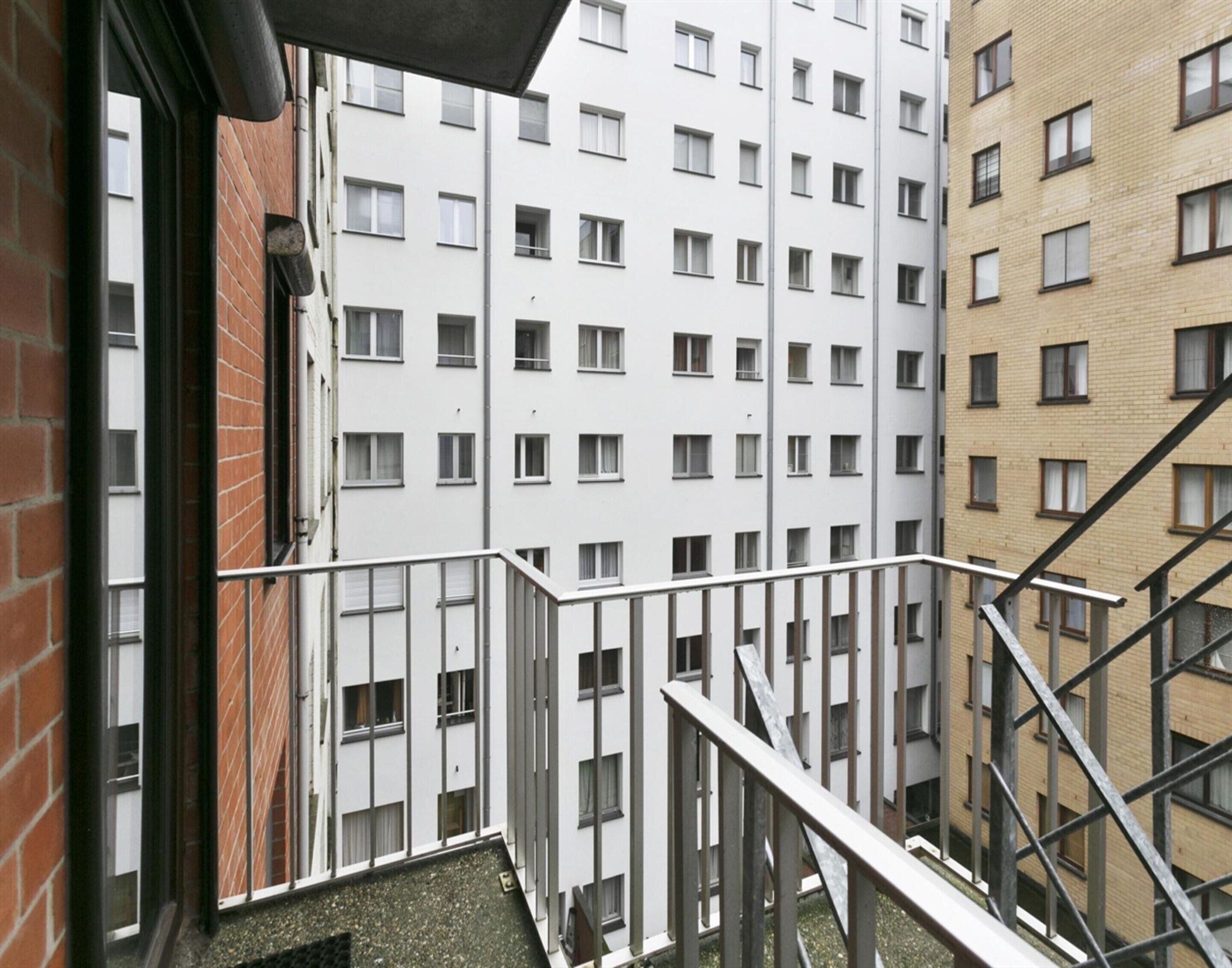 Un edificio residenziale a più piani con facciata in mattoni e pareti esterne bianche.