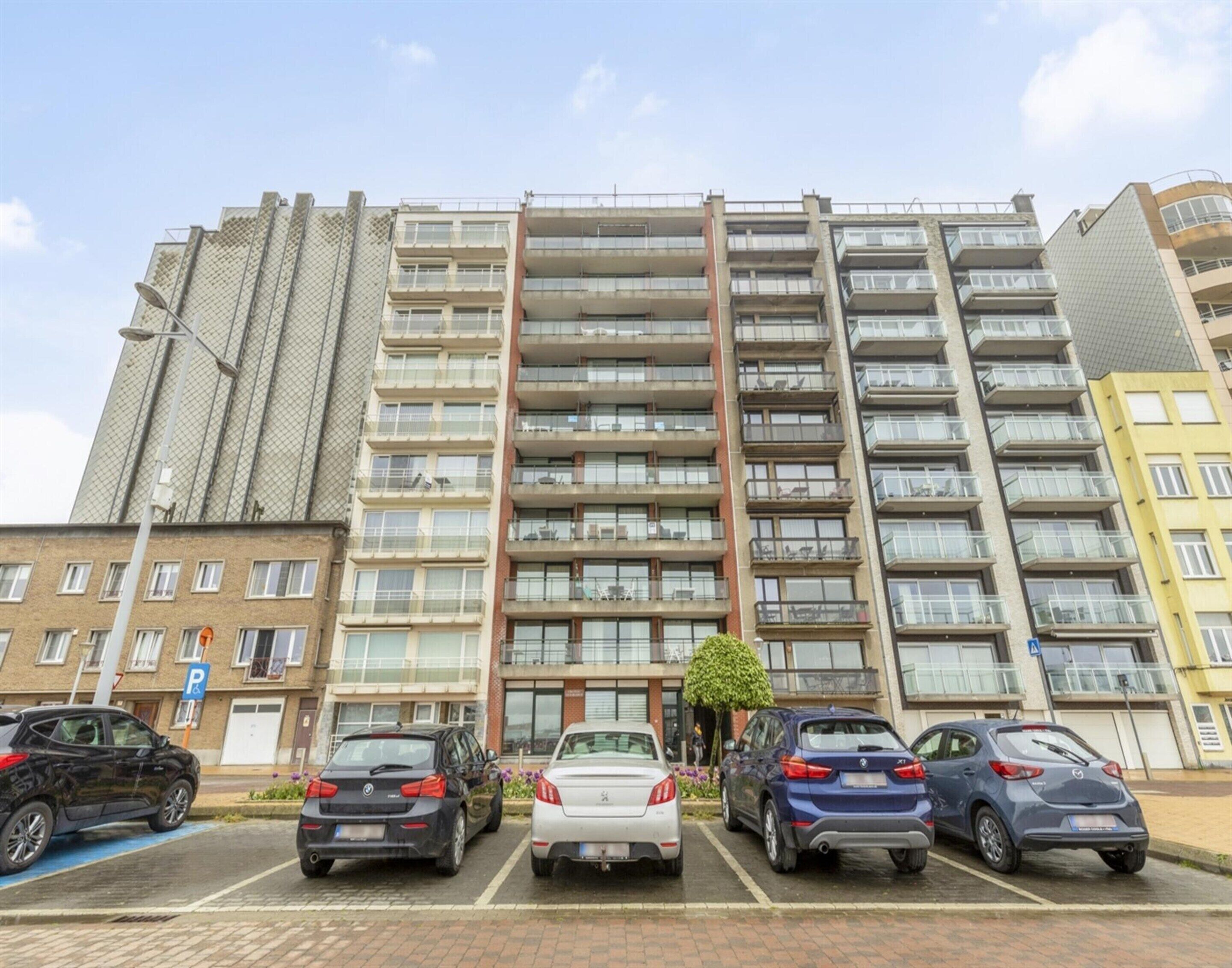 A multi-story parking garage with several cars parked in designated spaces.