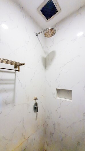 A bathroom with a shower, a towel rack, and a small shelf. - La'rissa Residence by ARBA (Karawang)