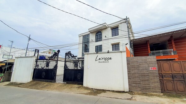 A gated residential property named "La'Rissa Residence" with a white exterior, a gated entrance, and a visible staircase leading to the main entrance. - La'rissa Residence by ARBA (Karawang)
