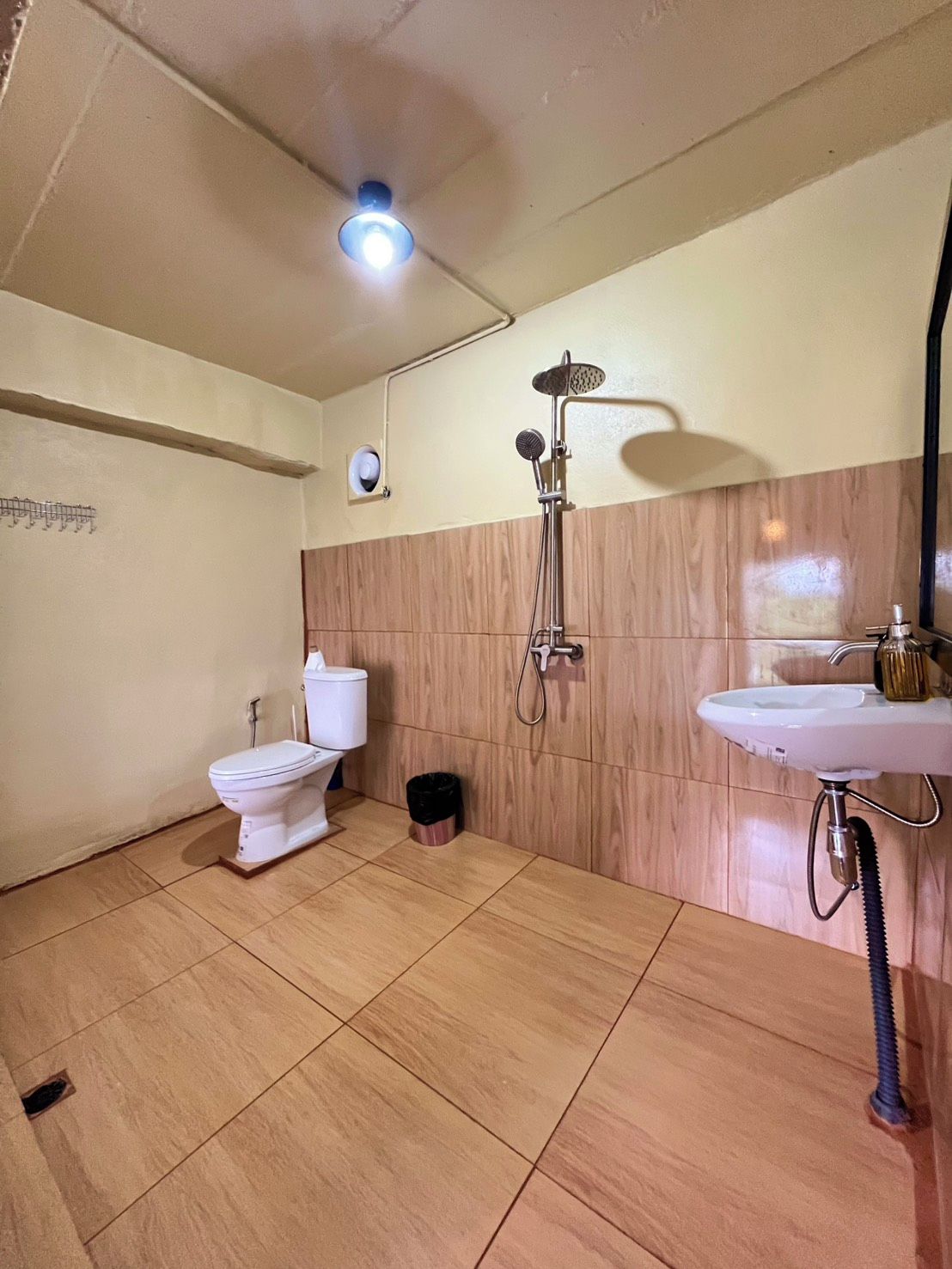 Une petite salle de bain comprenant des toilettes, une douche et un lavabo.