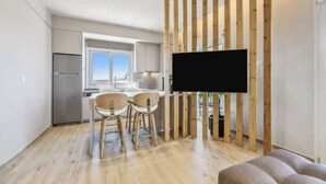 Een moderne keuken met een groot raam, een wand van houten panelen en een flatscreen televisie aan de wand bevestigd.