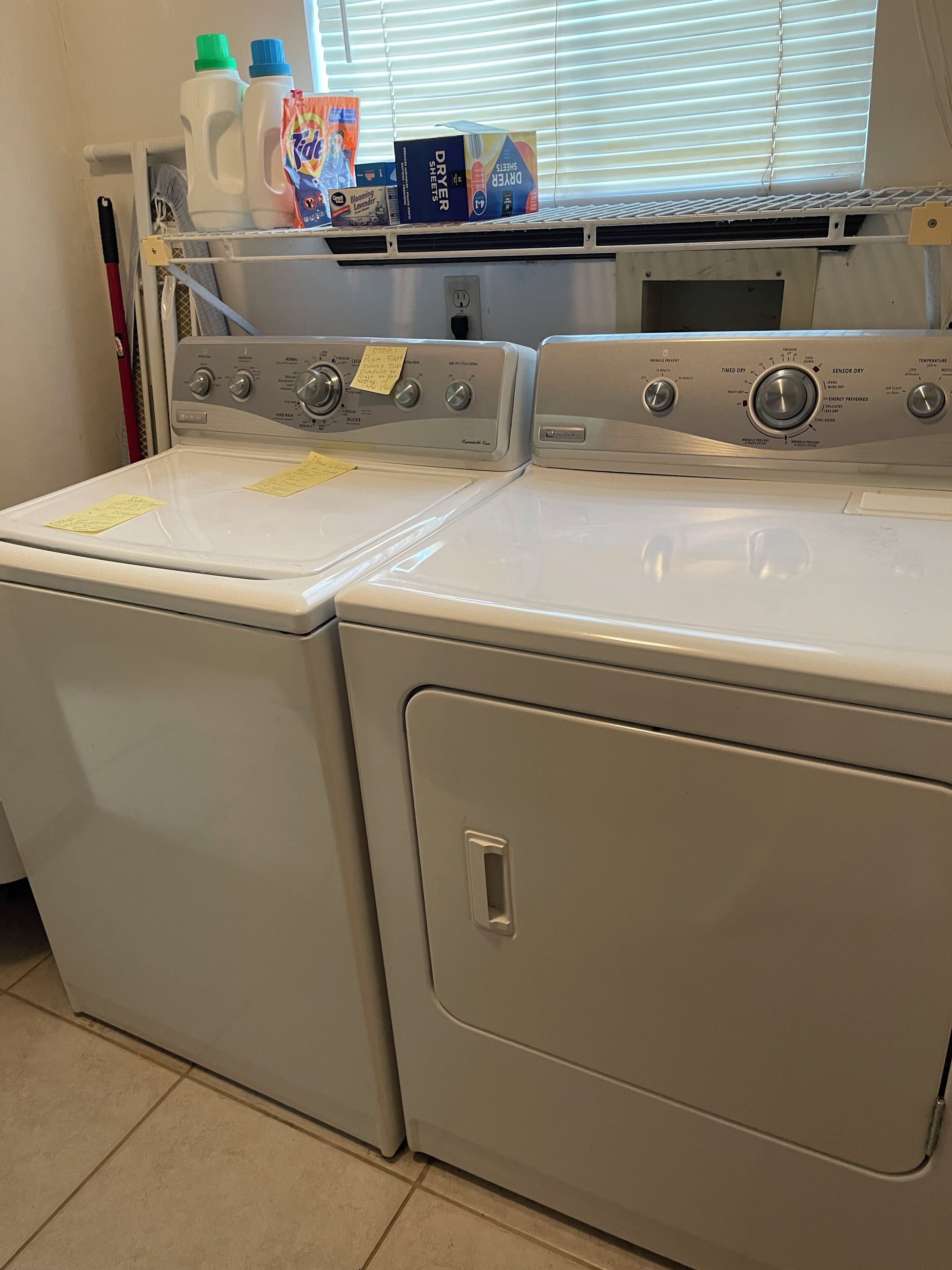 A front-loading washer and dryer with a window above the dryer.