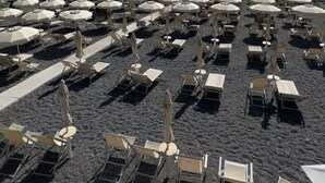 A beachside area with rows of sun loungers and umbrellas, a clear sky, and the ocean in the background. - Kalispera Residence  (Scalea)