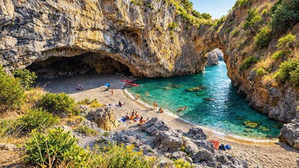 A coastal beach with rocky cliffs, clear turquoise water, and a cave entrance. - Kalispera Residence  (Scalea)