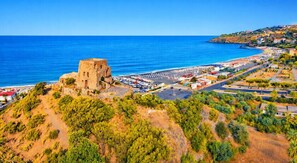 A coastal town with a historic stone building, a marina, and a hilly landscape. - Kalispera Residence  (Scalea)