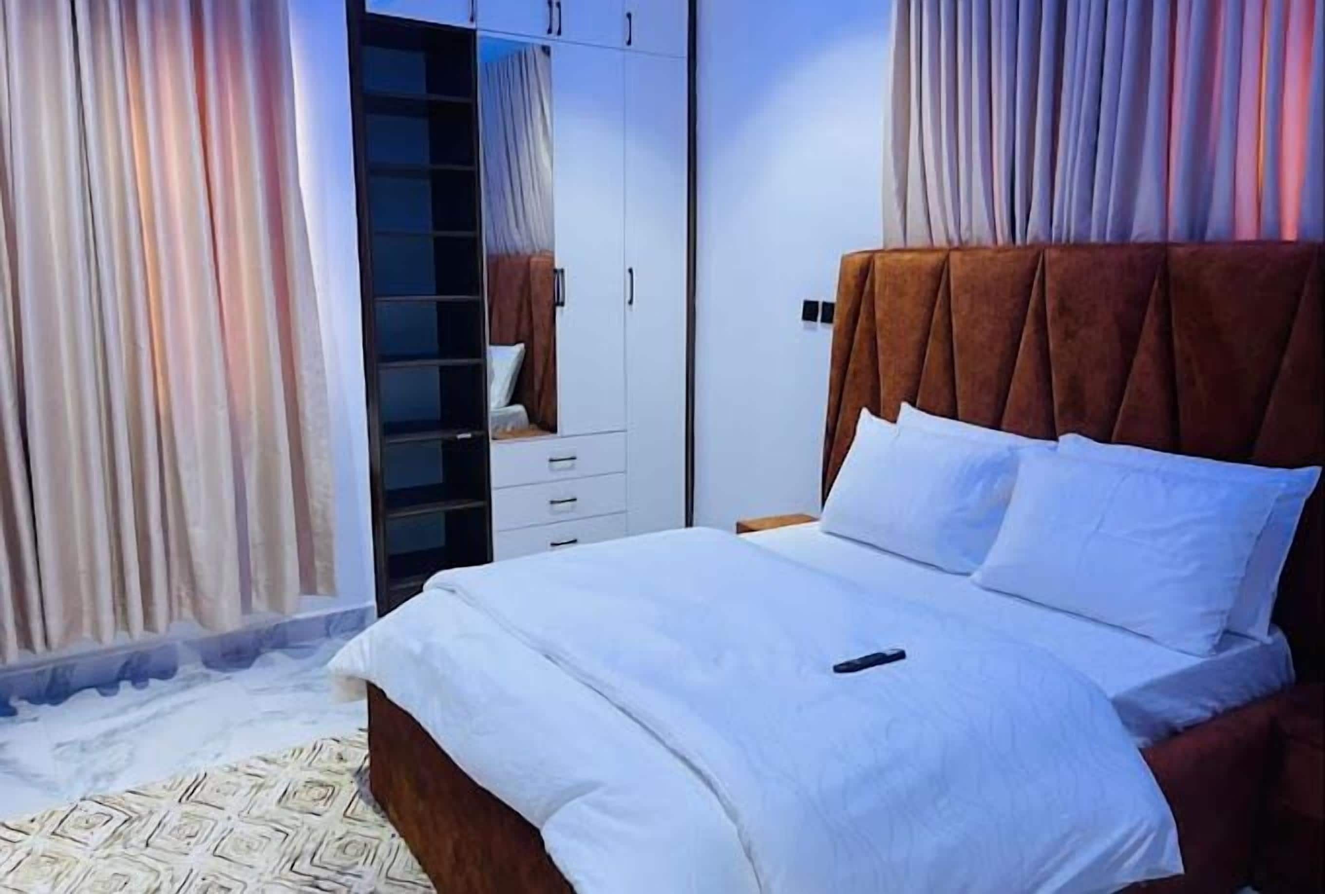 Un dormitorio con cama, armario y espejo.